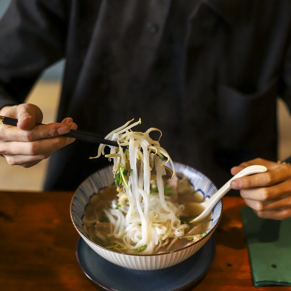 Guest enjoying phở at Pho & Roll